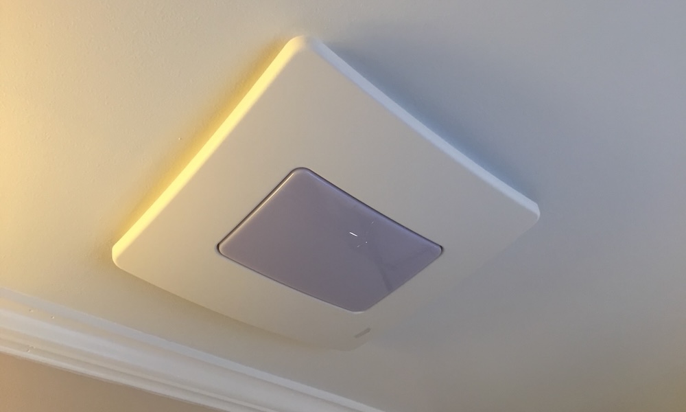A ceiling-mounted bathroom exhaust fan grille with visible dust buildup around the slats