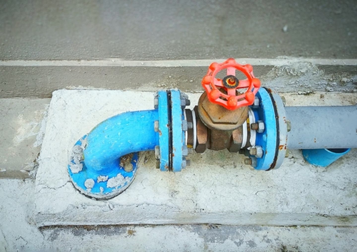 A home's main water shutoff valve installed on a copper service line near a foundation wall