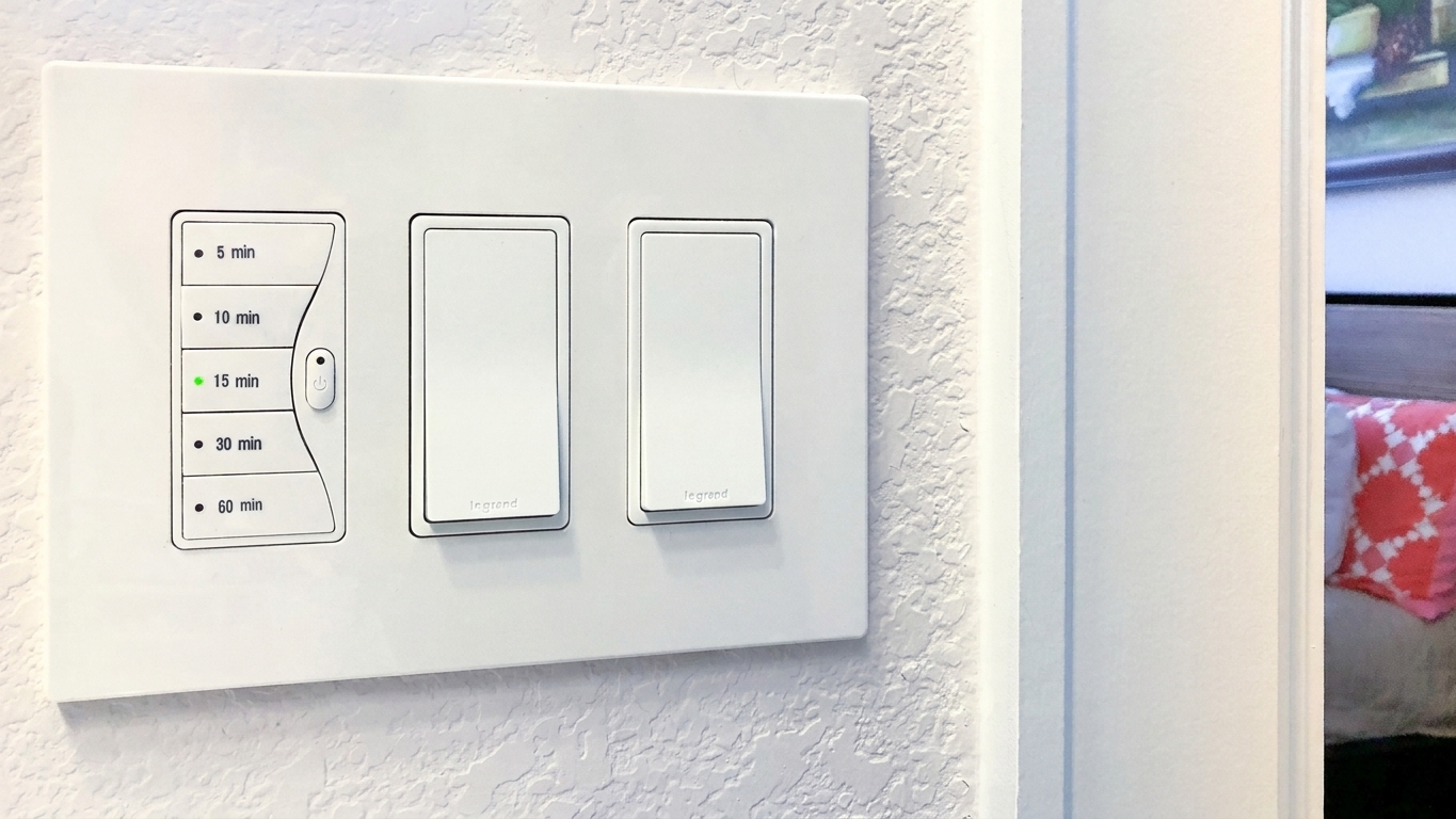 A newly installed bathroom fan timer switch mounted flush to the wall with the cover plate installed