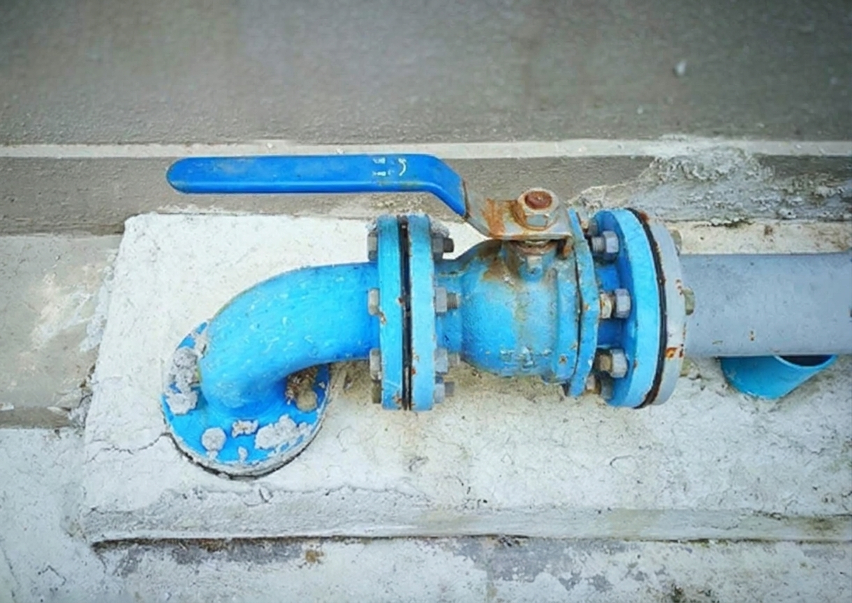 A quarter-turn ball valve main water shutoff with the handle aligned parallel to the pipe