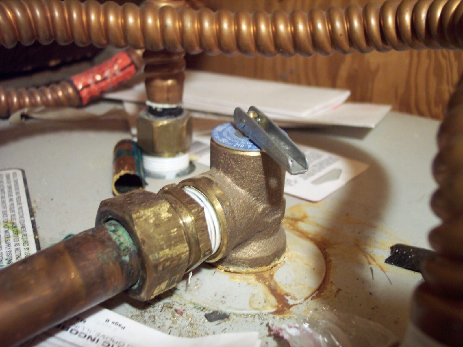 A quarter-turn shutoff valve on the cold water supply line above a water heater