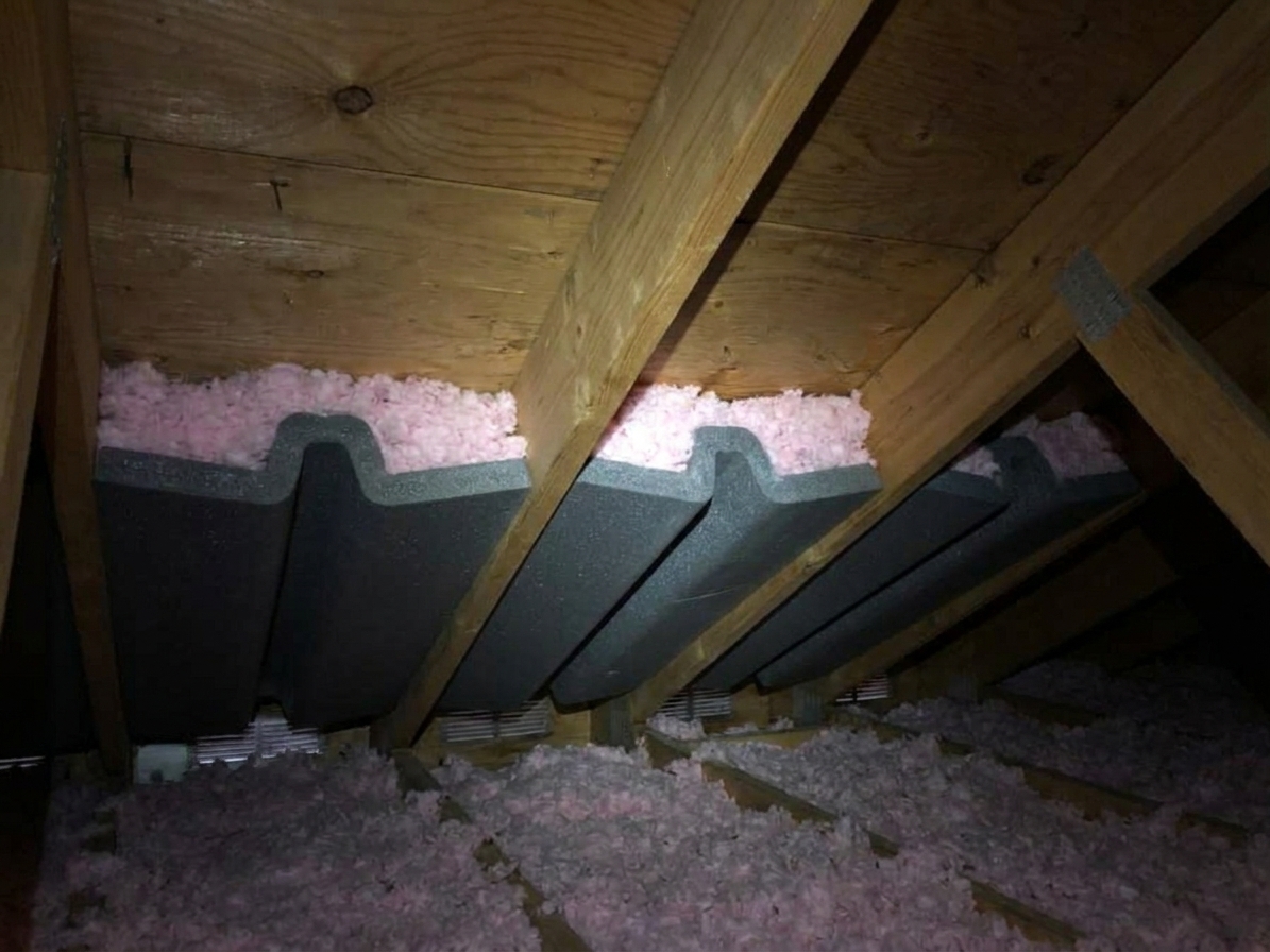 Foam or cardboard soffit baffles installed between rafters at the eaves to keep attic insulation from blocking soffit ventilation