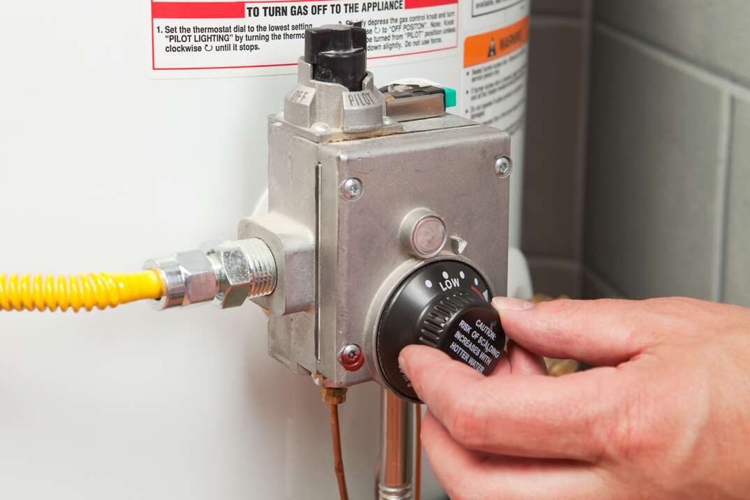 The pilot light viewing window on a gas water heater near the burner compartment